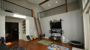 Picture of the interior of a home addition with a television and children's toys.