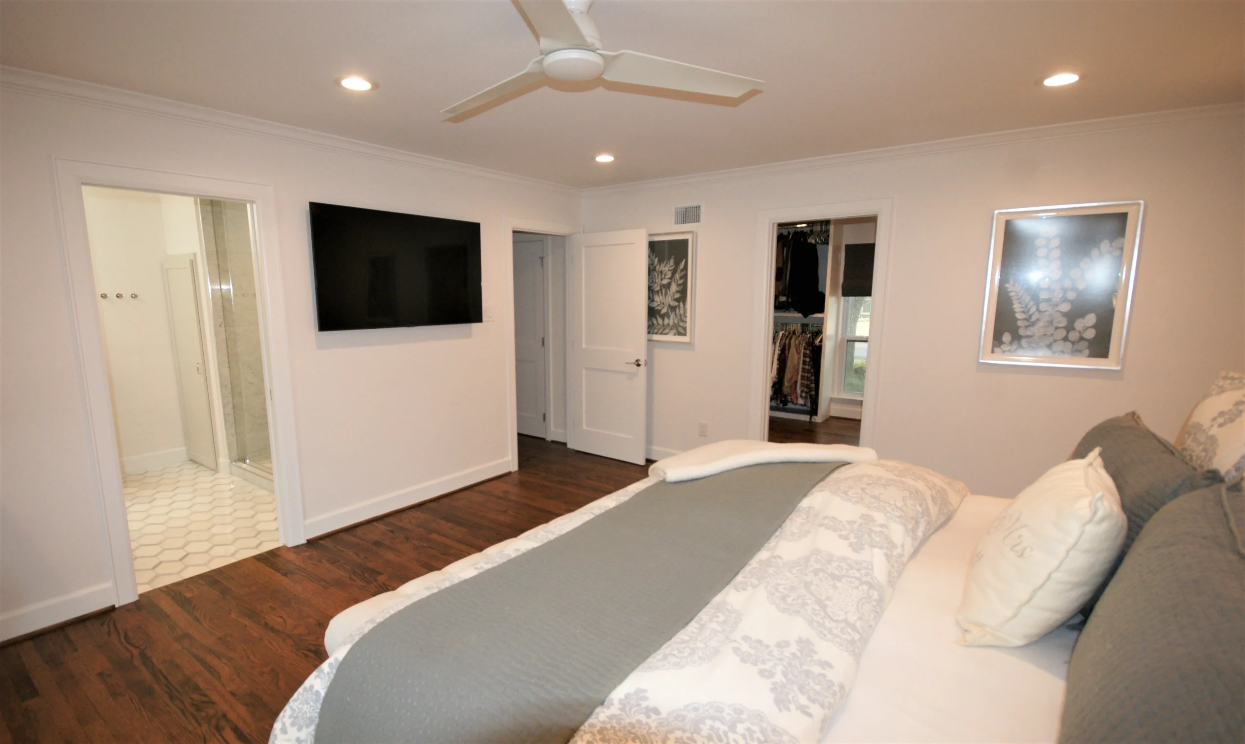 Modern bedroom with flat-screen TV and ensuite bathroom.