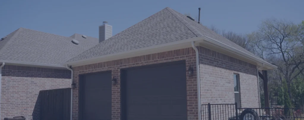 Brick garage with dark doors and gable roof.