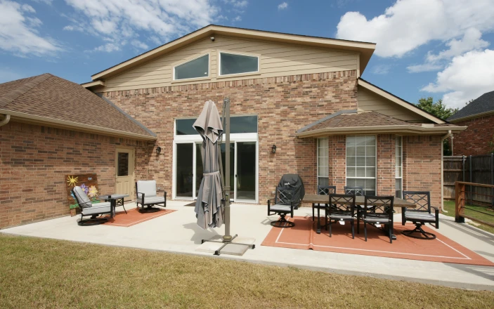 Brick house with patio furniture and umbrella