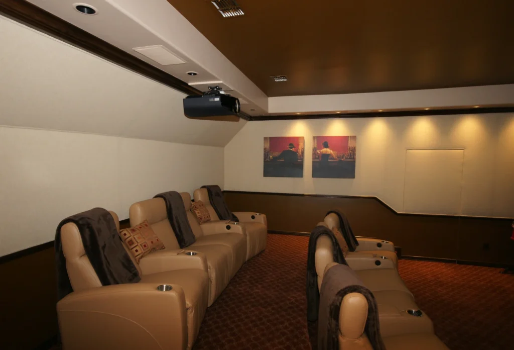 Luxury home theater with recliner seats and projector.