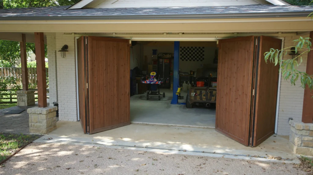 Wooden garage doors open to reveal workshop inside.