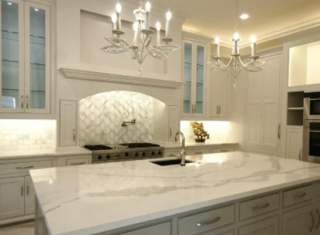 Luxurious modern kitchen with marble countertops and chandelier.